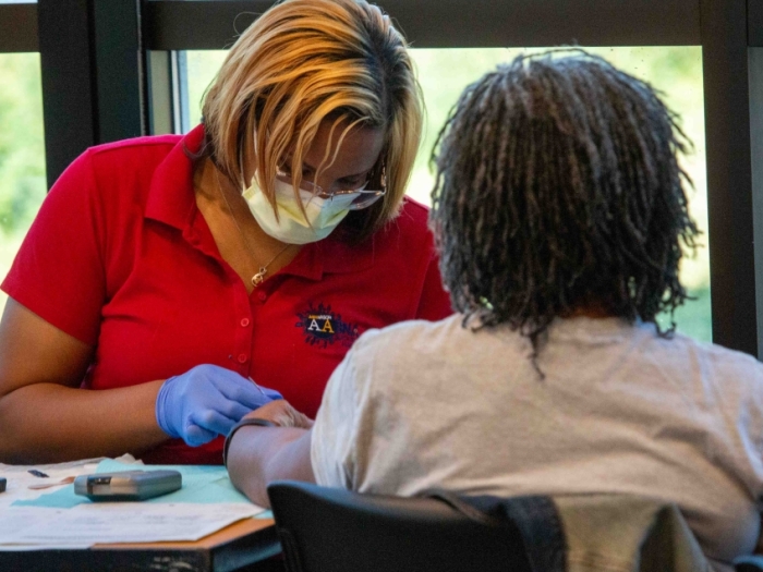 volunteer examines someone at flu clinic