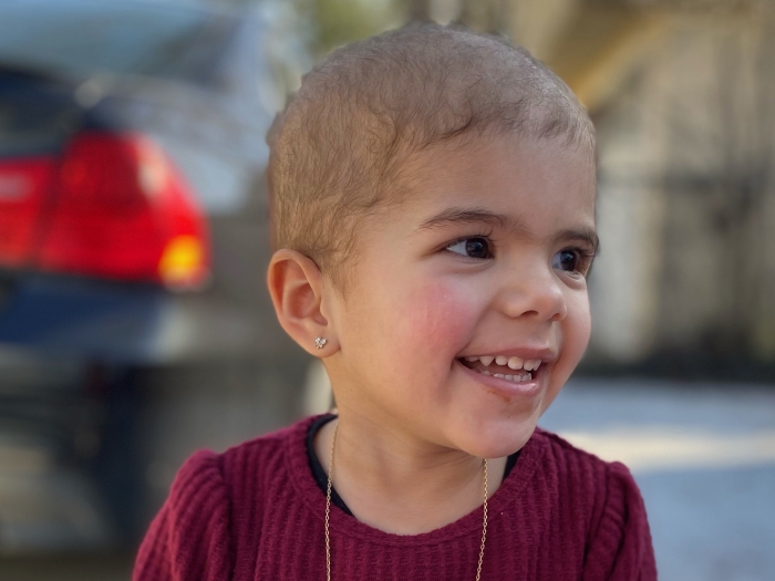 Toddler Martina smiling.