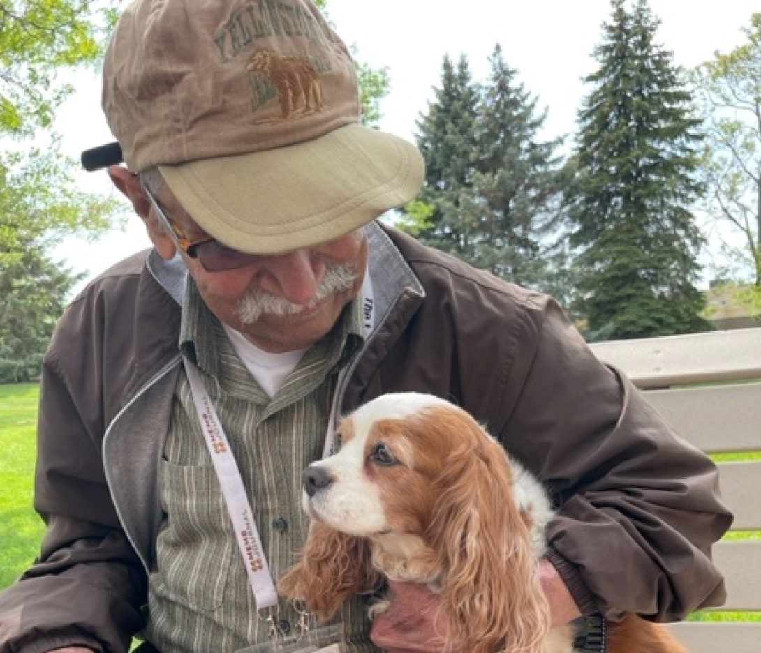 Silver club member holds a dog and smiles